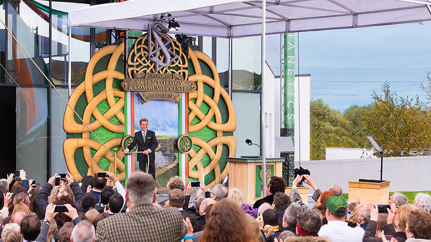 Před rozsáhlým davem shromážděným v očekávání vede zasvěcení nové budovy Scientologické církve v Dublinu pan David Miscavige.
