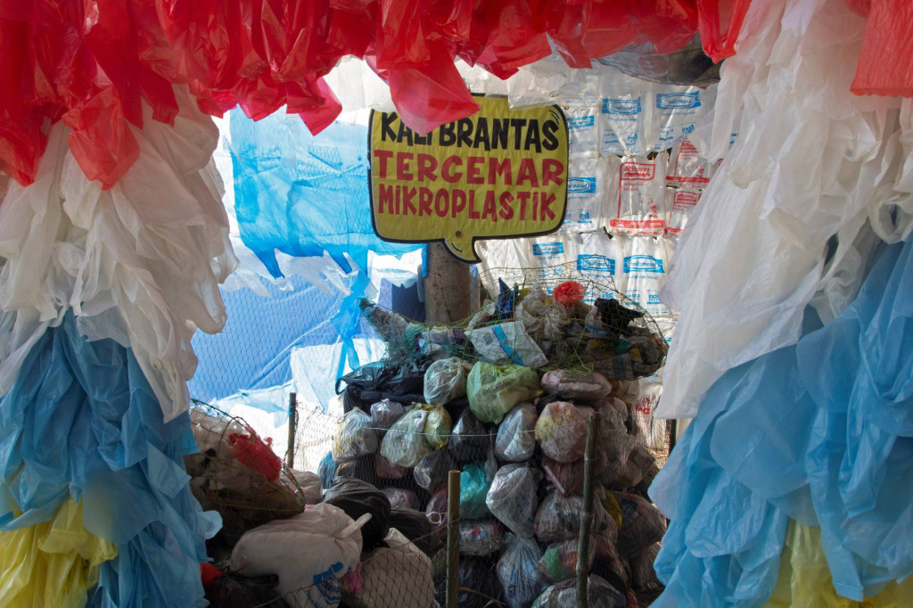 Nálepka s nápisem „Řeka Brantas znečištěná mikroplasty“ stojí mezi plastovými sáčky vystavenými v muzeu plastů, které v září 2021 vybudovala indonéská ekologická skupina Ekologické pozorování a ochrana mokřadů poblíž Surabaya v Indonésii.